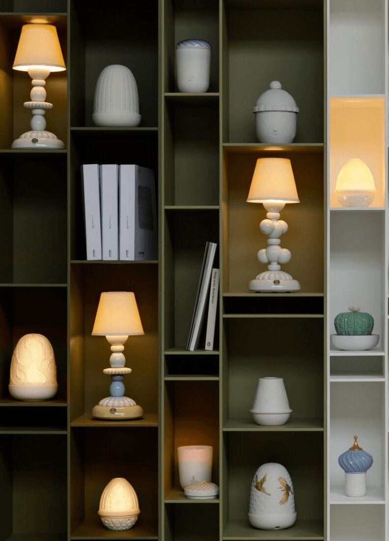 Lladró - Cactus Firefly Table Lamp - White displayed among various porcelain lamps on shelves.