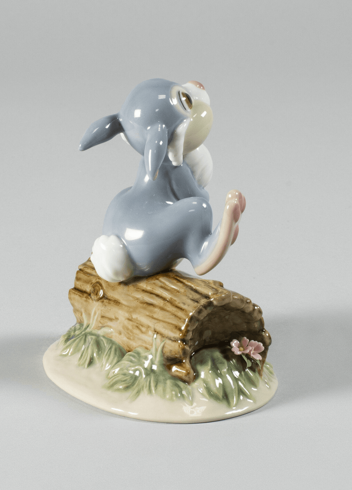 Lladró - Thumper Figurine, glazed porcelain bunny smiling on a log, ideal for collectors.