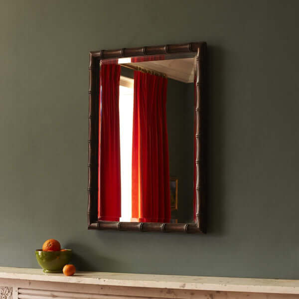 Pooky - Baloo Mirror - Ebony Finish reflecting vibrant red curtains in a stylish interior setting.