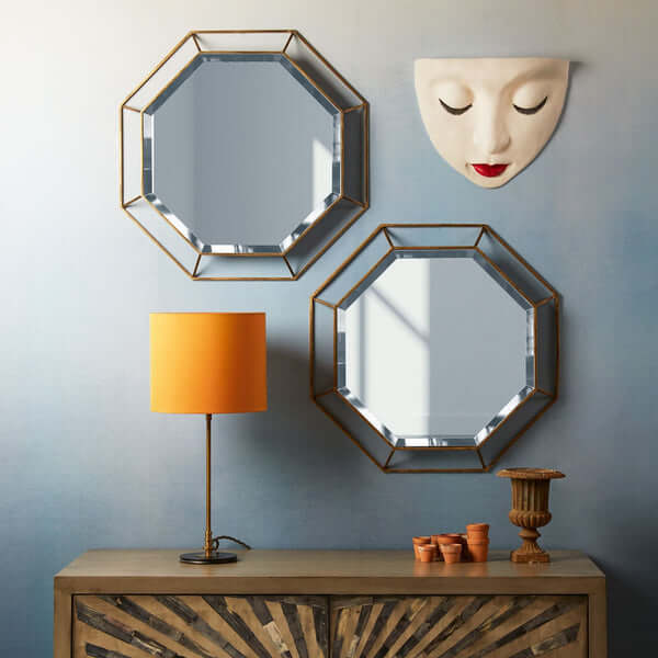 Pooky - Octagon Mirror - Clear Glass with Antique Gold Frame displayed in a stylish interior setting with lamps.
