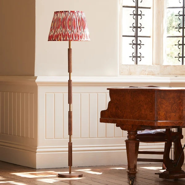 Pooky - Skellig Floor Lamp Base - Burnt Wood And Brass - Without Lampshade styled next to a wooden piano in a sunlit room.