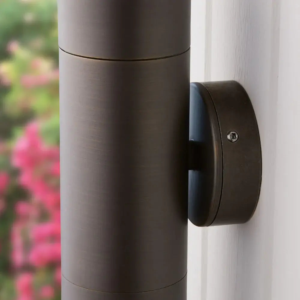 Close-up view of the Pooky Portreath IP65 Up and Down Pillar wall light in Bronze mounted on a wall.