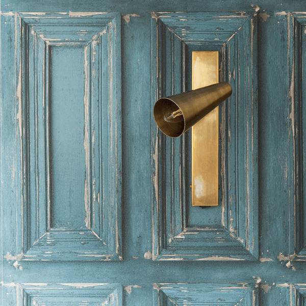 Pooky - Victor Wall Light - Antique Brass mounted on a blue distressed wooden wall.
