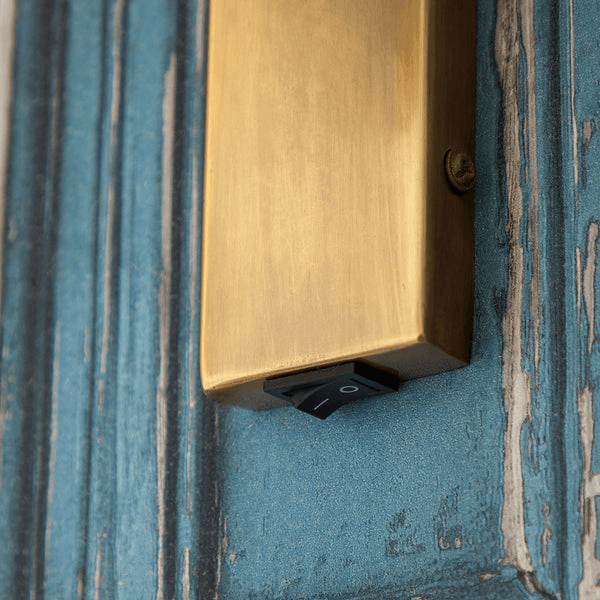 Pooky - Victor Wall Light - Antique Brass switch detail on blue wood background.
