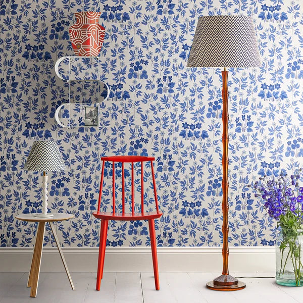 Pooky - Bamboo Floor Lamp Base - Amber Polished Resin - Without Lampshade next to a red chair.