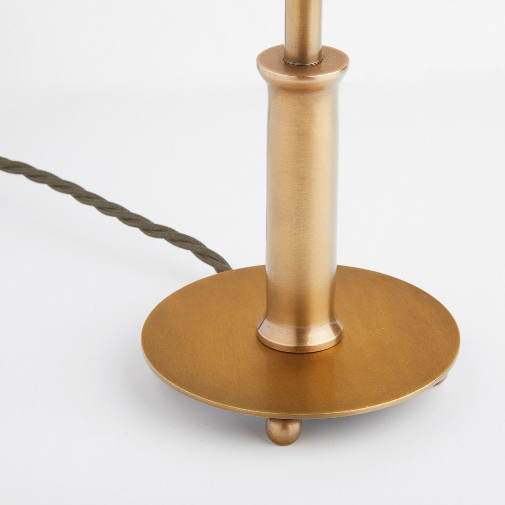 Close-up of the Pooky - Regular Pod Table Lamp Base - Antique Brass featuring a circular base and ball feet.